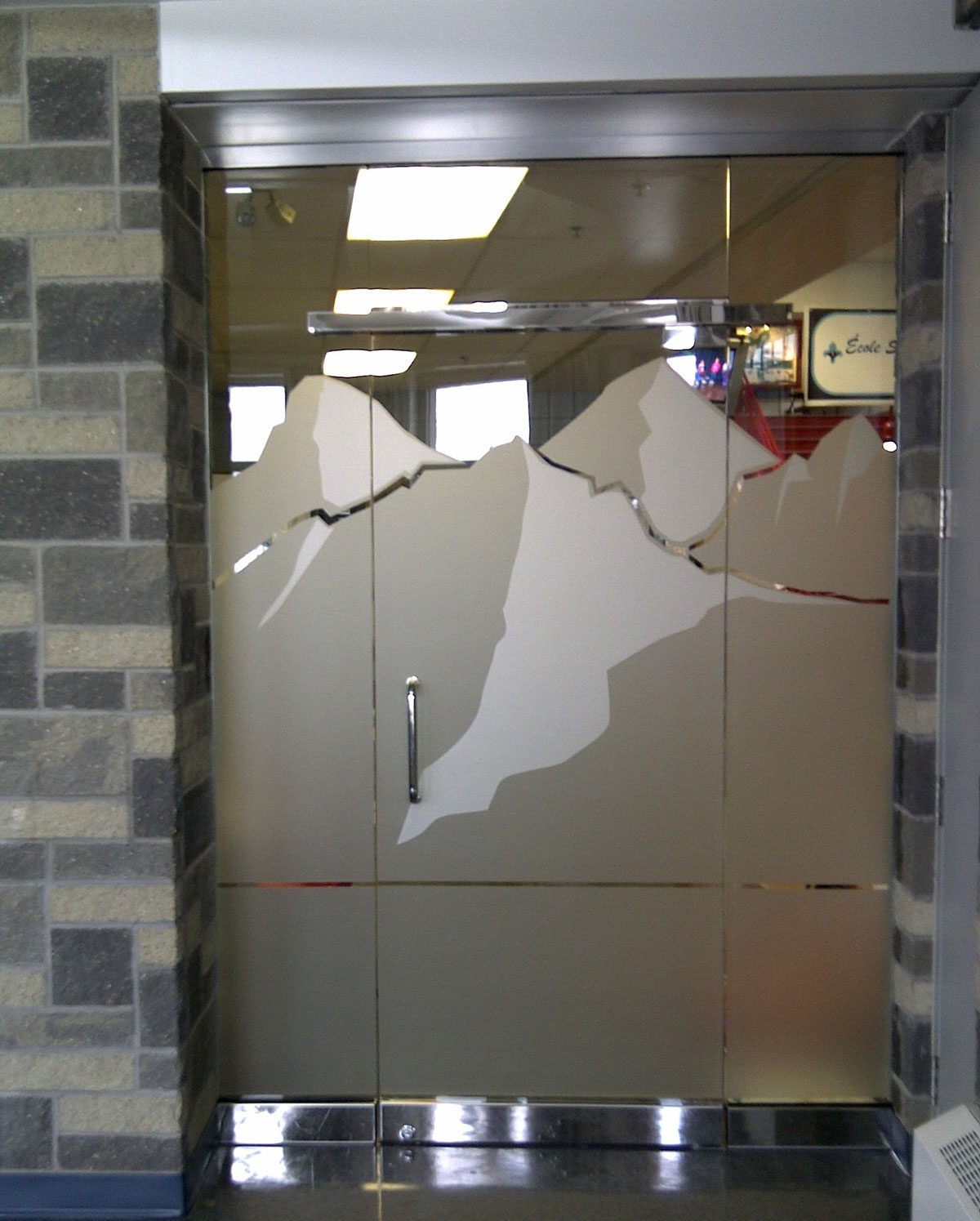 Frosted etched mountains on a glass door.